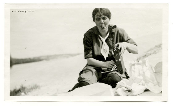 Beach woman holding fold-out camera, circa 1910