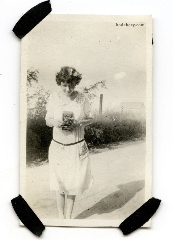 Vintage snapshot of a girl holding an old camera